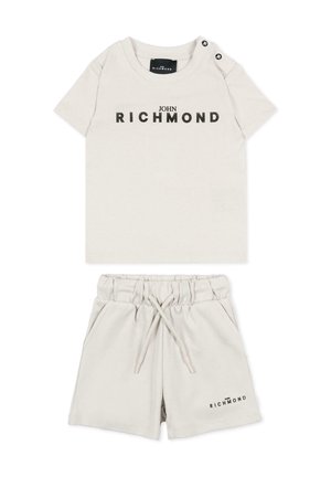 Beżowy zestaw dwu-częściowy dla malucha z krótkimi rękawami i szortami, z czarnym logo "John Richmond" na piersi i dolnej lewej stronie szortów.