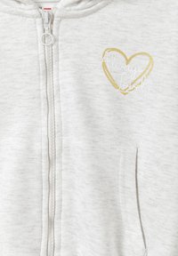 Sudadera de cremallera gris claro de material suave; presenta un corazón con contorno dorado y el texto "Siempre Encantadora"; incluye bolsillos frontales y capucha.