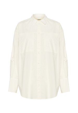 Valge puuvillane särg, millel on pika varrukaga ja kaks eesmist taskut, klassikaline krae. Omab mugavat lõiget ja pehmet tekstuuri.