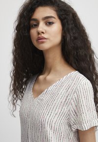 Blusa a scollo a V in tessuto leggero, con motivo a righe in tonalità di rosa, blu e nero. Maniche corte e vestibilità comoda.