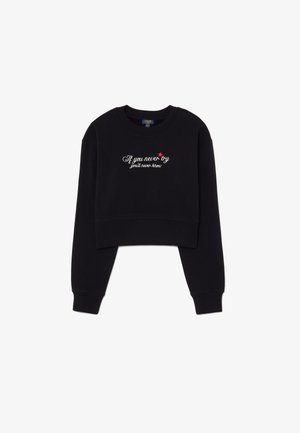 Sudadera negra recortada de algodón, con mangas largas y cuello redondo. Texto en el frente que incluye una estrella roja y bordado blanco.