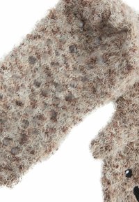 Mănușă pufoasă, texturată, în nuanțe de bej și marron, cu un model punctat. Material moale, cu detalii de suprafață tactile distincte.