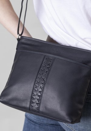 Marineblaue Leder-Umhängetasche mit geflochtenem Detail in der Mitte, flachem Design und verstellbarem Riemen. Strukturiertes Oberflächenmaterial mit zartem Glanz.