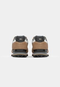 Bruine suède sneakers met grijze en witte accenten, een gevoerde hak en een zwarte tussenzool. Geribbelde rubberen zool voor grip.