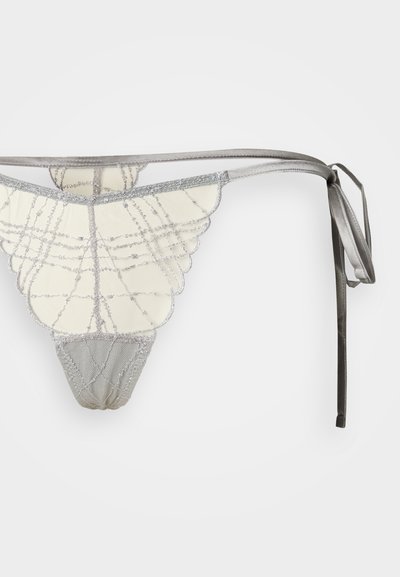 Stringi do bielizny w kolorze kremowym ze srebrnymi akcentami, z wzorem przypominającym koronkę, z falistymi krawędziami i satynowymi wiązaniami. Miękka faktura i misterny design.