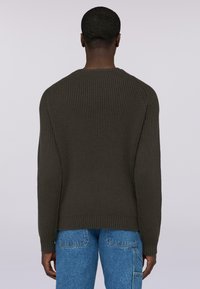 Tmavě olivově zelený žebrovaný pletený svetr s dlouhými rukávy, kulatým výstřihem a přiléhavým lemem, pohled zezadu. Klasický neformální design.