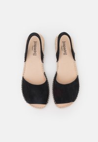 Svarta mocka espadrillos med öppna sidor, rundad tå och sula av naturfärgad väv. Minimalistisk design med kontrasterande sömdetaljer.