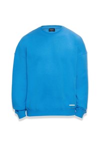 Blå sweatshirt laget av mykt stoff, med rund hals, ribbede mansjetter og en liten etikett på nederste kant. Enkel, ren design.