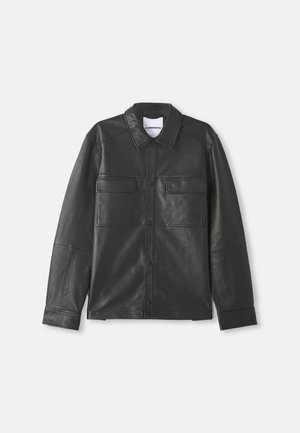 Schwarze Lederjacke mit Druckknöpfen, zwei vorderen Brusttaschen mit Klappen, langen Ärmeln und klassischem Kragen, flach präsentiert.