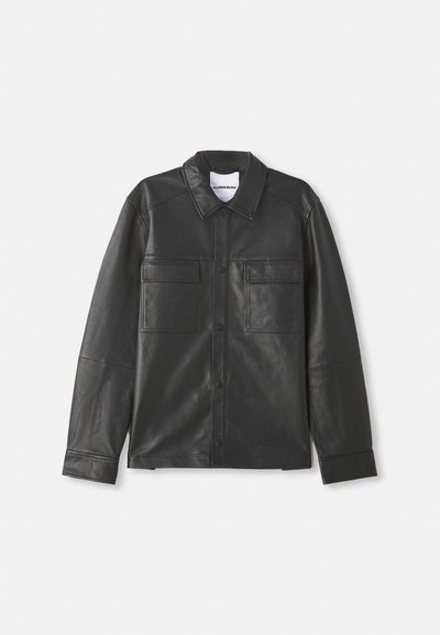 Black leather jacket with snap buttons, two front chest pockets with flaps, long sleeves, and classic collar, displayed flat.