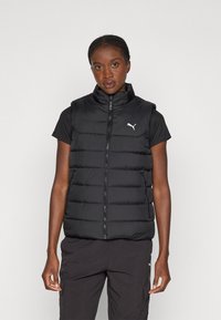 Vesta neagră îmblănită cu guler înalt, închidere cu fermoar în față și buzunare laterale. Prezintă logo-ul Puma pe pieptul stâng. Finisaj texturat.