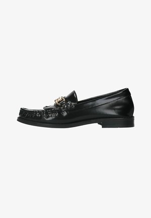 Black leather loafer with a rounded toe, decorative gold hardware, fringed detailing along the vamp, and a low, flat heel.