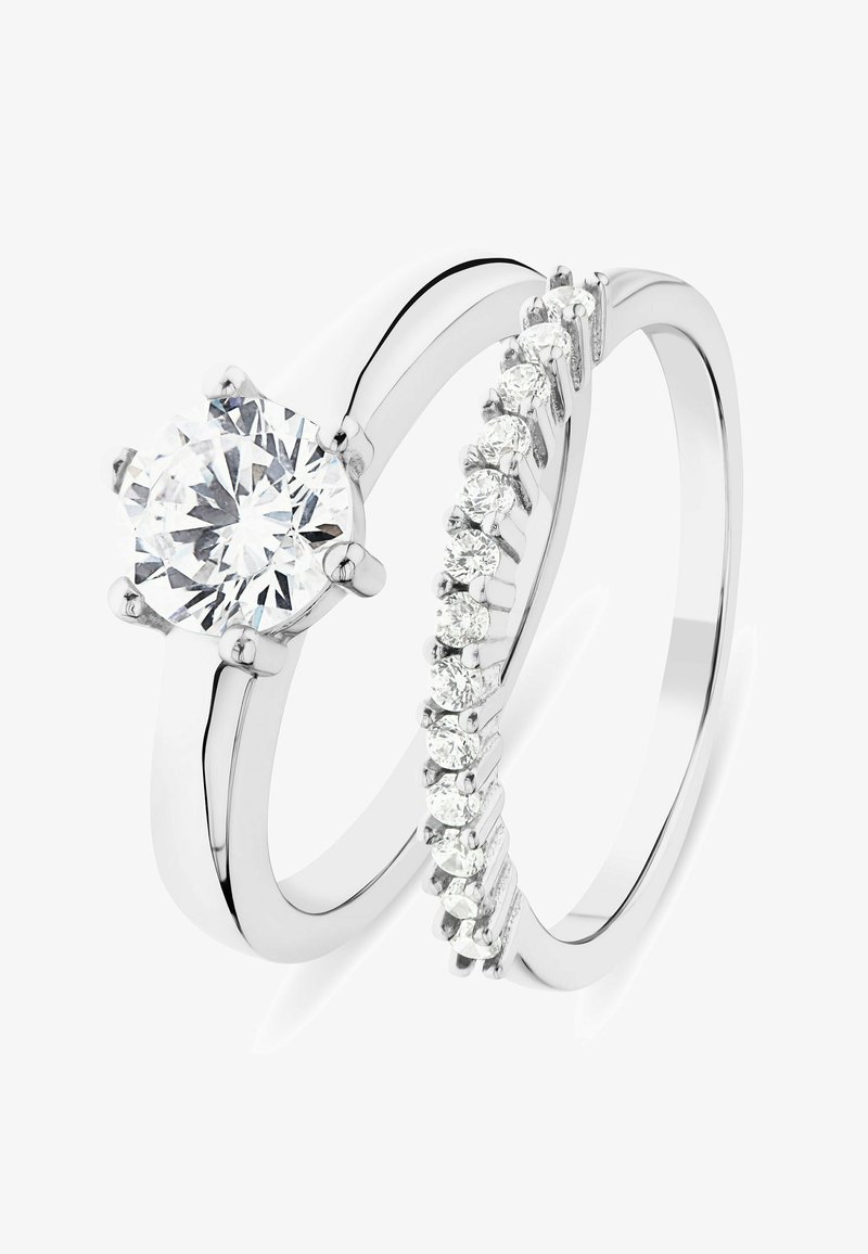 Silver wedding ring set featuring a large, round, prong-set diamond and a matching band with smaller diamonds in a channel setting.