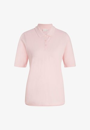 Lichtroze polo met korte mouwen, gecombineerd met witte shorts en grijze enkelsokken. Model draagt witte sneakers. Soepele stoftextuur.