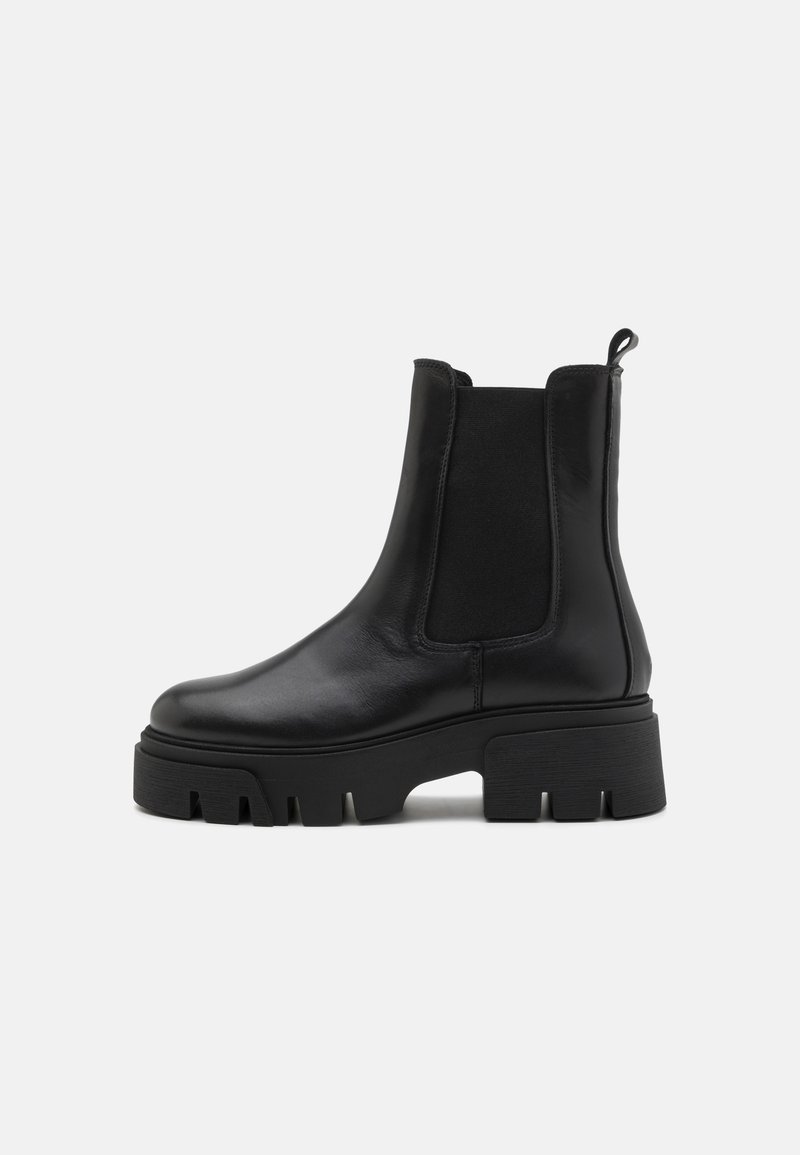 Black leather ankle boots with elastic side panels, round toes, and chunky rubber soles featuring pronounced grooves for traction.