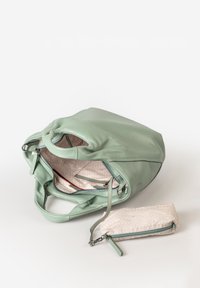 Borsa a mano verde in pelle con una consistenza morbida, dotata di una tasca interna con zip e di una piccola pochette coordinata con un motivo geometrico.