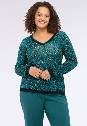 Maglione in maglia a motivi turchese e nero con scollatura a V, maniche lunghe e polsini e orlo a coste neri. Tessuto liscio con design a zigzag.