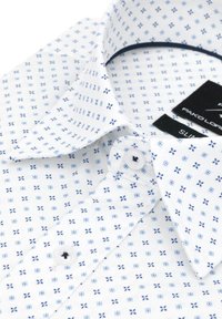 Biała koszula z małym niebieskim kwadratem i wzorem kwiatowym, z kołnierzykiem zapinanym na guziki oraz zapięciem z przodu. Tkanina jest gładka z wyraźną strukturą.