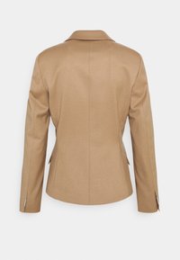 Blazer marrone su misura con rever, maniche lunghe e fessure laterali. Realizzato in un tessuto liscio con finitura opaca.