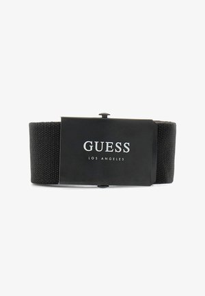 Cintura in tessuto nero intrecciato con una superficie liscia e una fibbia metallica con marchio, che presenta "GUESS LOS ANGELES" in lettere argentate in grassetto.
