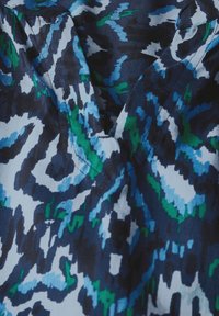 Patroonstof met een abstract ontwerp in marineblauw, blauw en groen. Het heeft een V-halslijn en een gladde, licht gestructureerde oppervlakte.