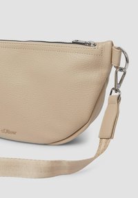 Borsa a tracolla in pelle beige con finitura texture, chiusura con zip e hardware in metallo argentato. Presenta una tracolla rimovibile e un dettaglio con logo impresso.