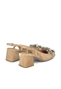 Tacchi slingback in suede beige con tacco largo e decorazioni in argento e cristallo sul davanti. Cinghia regolabile inclusa.