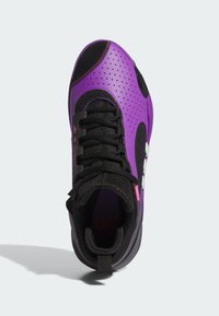 Botte de sport violette et noire avec un dessus texturé, un design perforé, un système de laçage et une languette au niveau du talon. Accents blancs visibles.