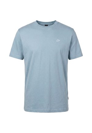 T-shirt bleu clair à manches courtes et col ras du cou avec un petit logo minimaliste blanc en forme de visage sur la poitrine gauche, fond uni.