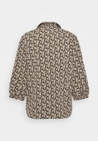 Camicia a stampa floreale con sfondo scuro e piccoli fiori rosa, maniche lunghe a palloncino e colletto classico. Texture del tessuto morbida.