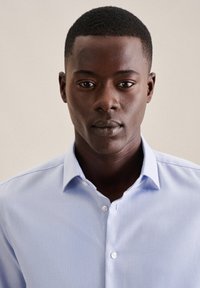 Lyseblå skjorte med knapp foran, klassisk krage og subtil tekstur, laget av bomull med en strukturert passform.