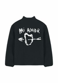 Pull-over en polaire noire avec col montant, arborant un texte graphique blanc « Mi Amor » et un cœur transpercé par une flèche dans le dos. Texture douce.