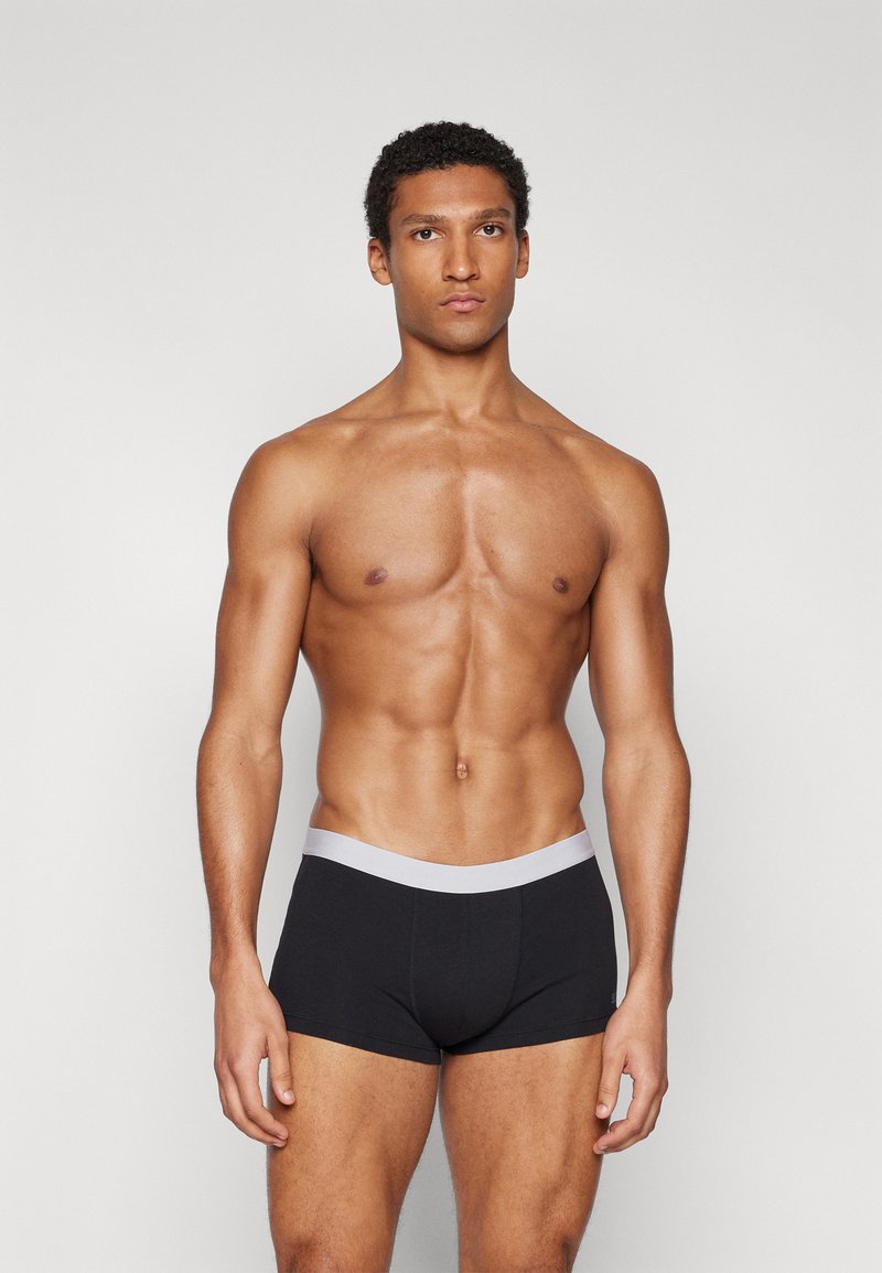 Schwarze Baumwoll-Boxershorts mit einem weichen grauen Bund, entworfen für einen engen Sitz mit glatter Textur und minimalistischer Stil.