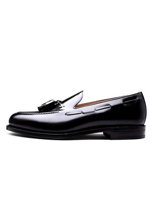 Zwart leren loafers met een gladde afwerking, voorzien van decoratieve stiksels en een metalen gespaccent. Rondneus en lage gestapelde hak.