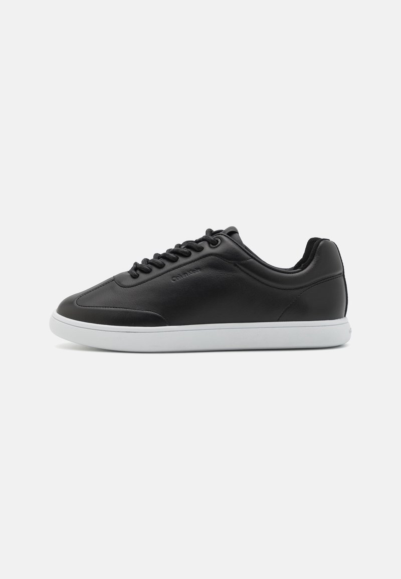 Black leather sneaker with a smooth finish, rounded toe, white rubber sole, and black laces. Features subtle branding on the side.
