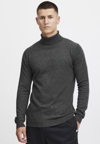 Dunkelgrauer Rollkragensweater aus weichem Material, mit langen Ärmeln und tailliertem Design sowie gerippten Bündchen und Saum.