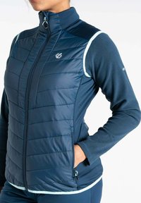 Marineblaue isolierte Jacke mit einem Reißverschluss auf der Vorderseite, gestepptem Design am Körper, Fleece-Ärmeln und hellblauen Akzenten entlang der Nähte. Verfügt über Seitentaschen.