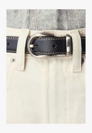 I pantaloni in denim bianco presentano una cintura in pelle nera con una fibbia argentata e cuciture a contrasto, evidenziando la loro texture e design.