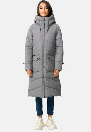Manteau long en duvet gris avec capuche, doté d'une fermeture éclair, de deux poches avant et d'un design matelassé. Assorti à un jean foncé et des baskets.