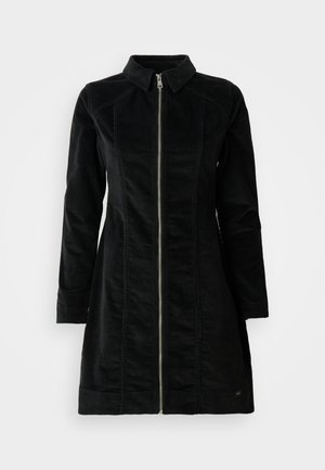 Giacca in corduroy nera, con colletto alto, maniche lunghe e zip frontale, dal taglio dritto e design minimalista.