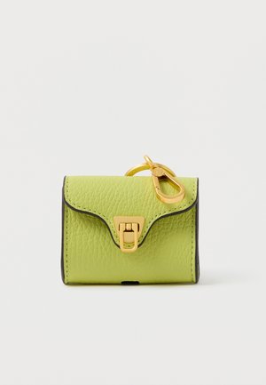 Maža žalia odinė rankinė su tekstūruotu paviršiumi, auksinės spalvos detalėmis ir juodu apvadu. Turi užsegimą su segtuku ir dekoratyvų raktų pakabutį.