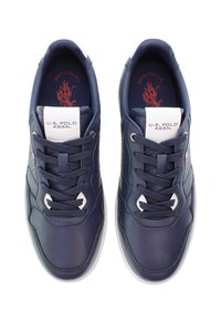 Námořnické modré syntetické tenisky s bílou podešví, kulatou špičkou, šněrovacím designem a logem na jazyku. Obsahují perforované detaily po stranách.