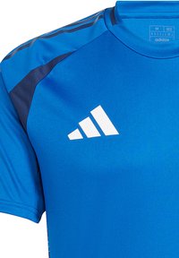 Blauw sportshirt met korte mouwen, gemaakt van soepele stof, met een wit Adidas-logo op de borst en donkere accenten op de schouders.