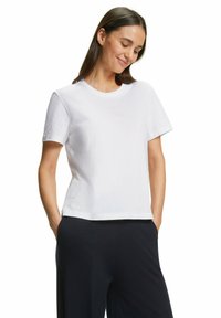 T-shirt bianco in cotone con scollatura rotonda, maniche corte e taglio dritto. Tessuto liscio senza motivi o dettagli visibili.