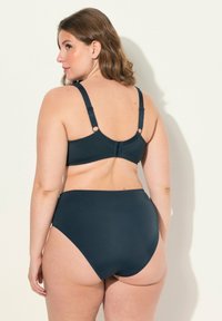 Tummansininen bikinit-setti, jossa on muotoiltu rintaliivi, jossa on säädettävät olkaimet ja hakaskiinnitys. Korkeavyötäröiset alaosa, jossa on sileä pinta.