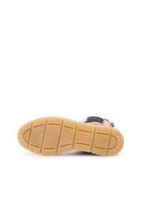 Black shoe sole with a textured, rubberized surface and light tan, ridged outsole. Features defined tread patterns for traction.