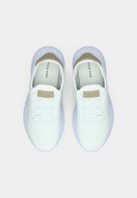 Białe siatkowe sneakersy o teksturowanym wzorze, z elastycznymi sznurowadłami, jasnoszarymi akcentami oraz grubą gumową podeszwą w kontrastowym jasnoniebieskim kolorze.