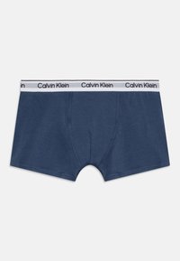 Tamno plave pamučne bokserice s bijelim elastičnim pojasom na kojem je ponavljajući natpis "Calvin Klein". Glatka tekstura i klasičan kroj.
