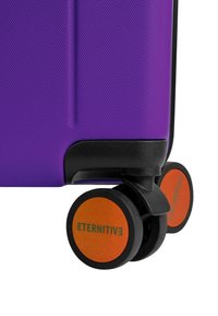 Paarse harde koffer met een gestructureerde oppervlakte, voorzien van zwarte accenten en oranje wielen met het label "ETERNITIV." Ronde wielontwerp voor mobiliteit.