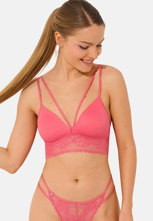 Roze kant bralette met verstelbare dubbele schouderbanden, een diepliggende halslijn en bloemmotief van kant bij de band. Zachte, gladde textuur.